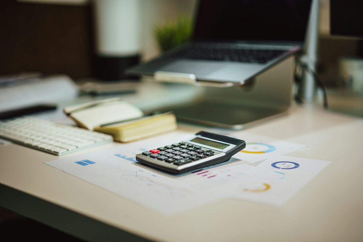 Calculator and financial charts on an office desk